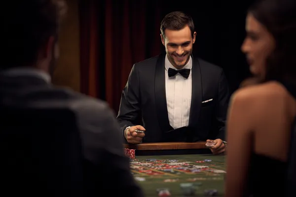 A woman in a luxurious green gown next to an ornate roulette wheel, capturing the upscale casino mood of 5XGAME.